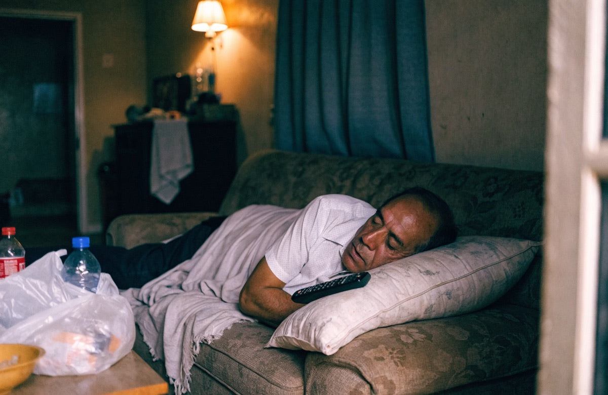 Hombre durmiendo en el sof&aacute; de la sala con una cobija